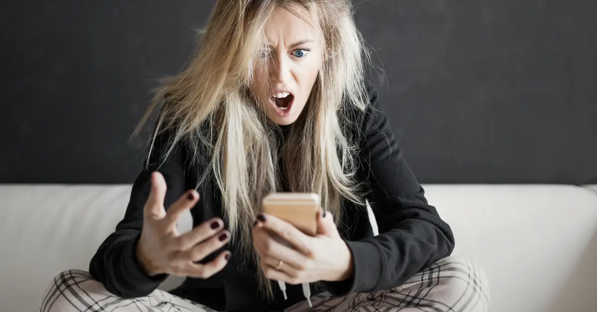 Woman upset while looking at her phone